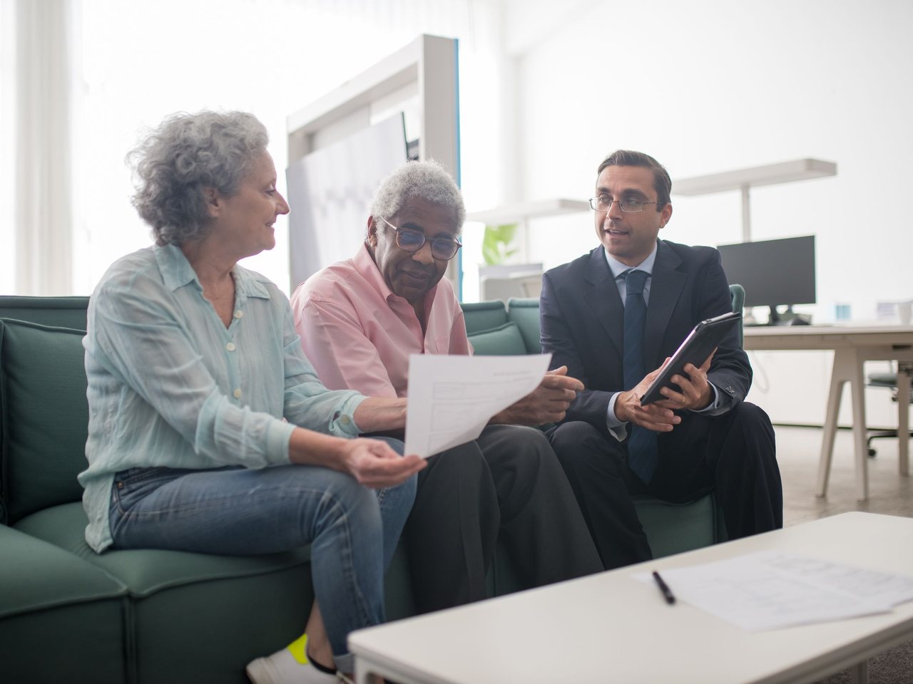 An advisor reviewing documents with a couple in an office